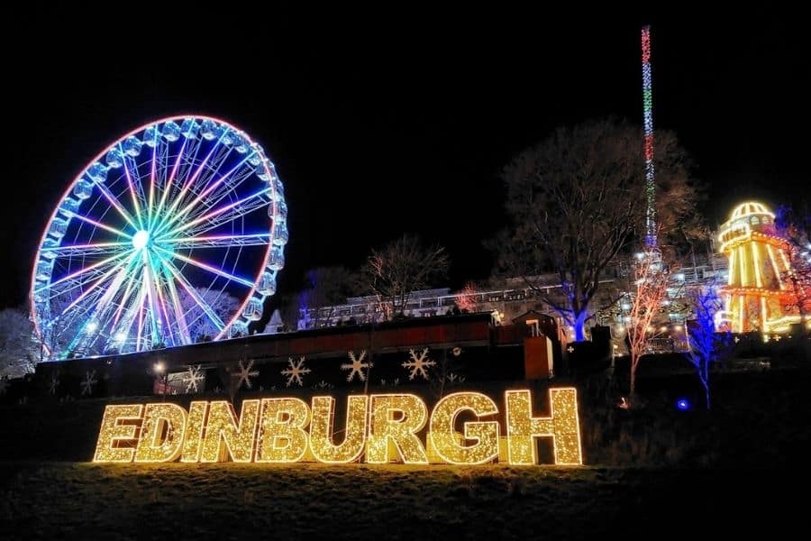 Illuminated Edinburgh sign and Big Wheel at Edinburgh Christmas Market at night